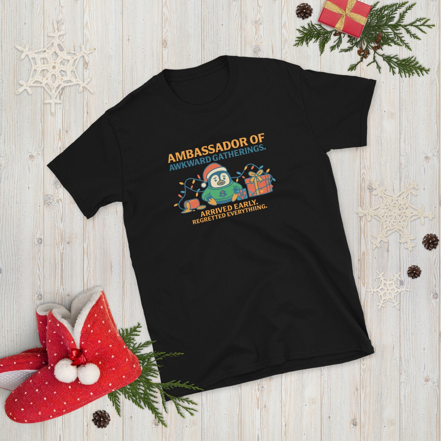 Black t-shirt with Christmas-themed design with a penguin and festive decorations.